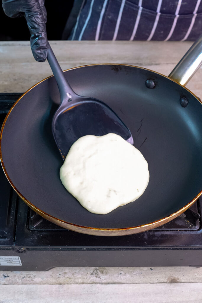 Flipping silver dollar pancake with spatula during cooking process