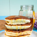 Fluffy Japanese pancakes with honey drizzle stacked on white plate