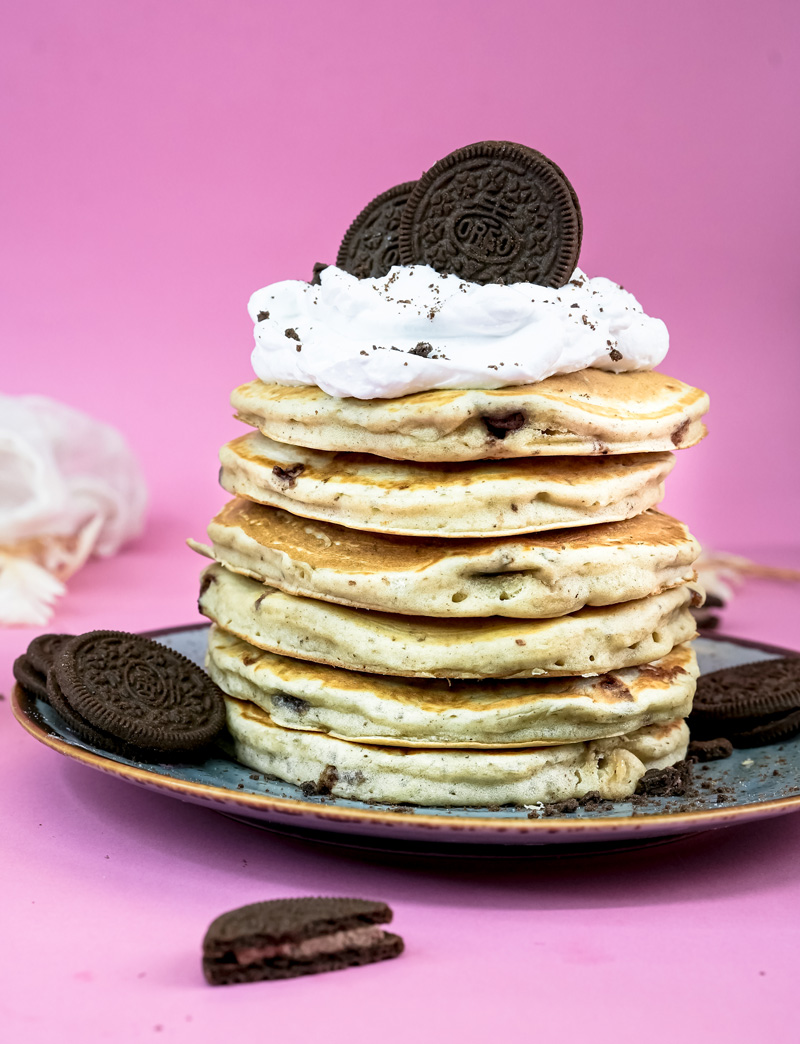 Fluffy Oreo pancakes stacked high with whipped cream and cookie garnish