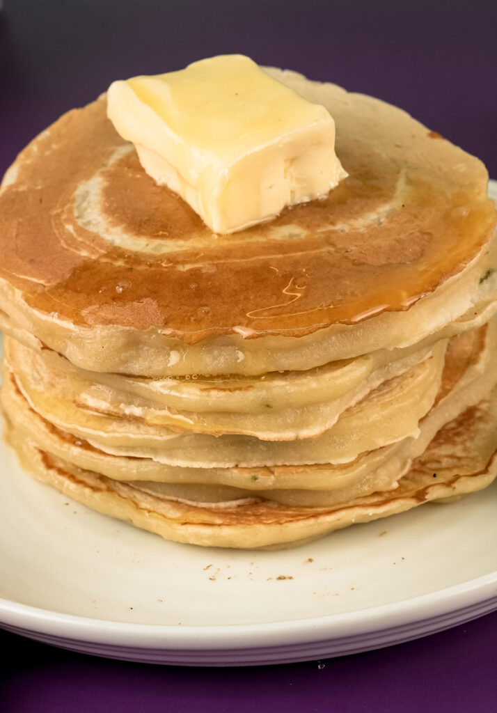 Fluffy lemon ricotta pancake stack topped with butter pat