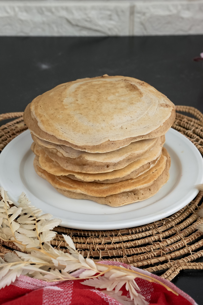 Fluffy whole wheat pancakes stacked on serving plate