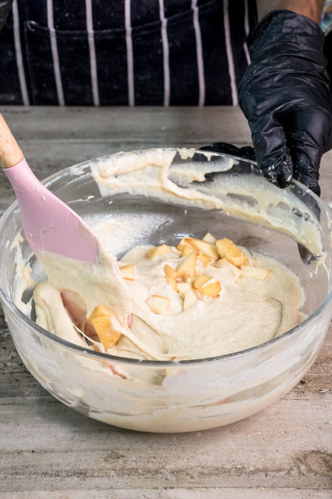 Folding fresh apple pieces into pancake batter