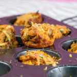 Freshly baked golden pizza muffins in purple muffin tin