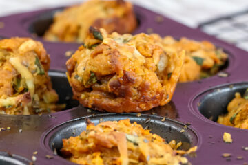 Freshly baked golden pizza muffins in purple muffin tin