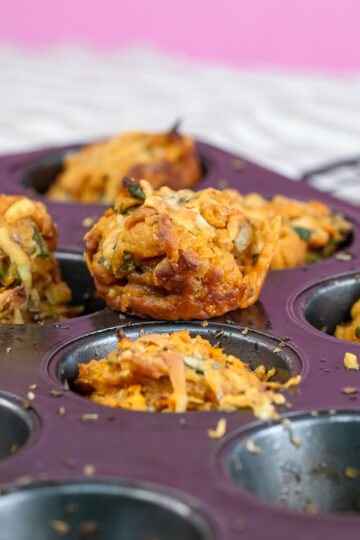 Freshly baked golden pizza muffins in purple muffin tin