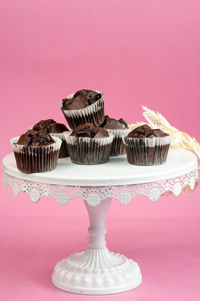 Freshly baked peanut butter banana muffins on white cake stand