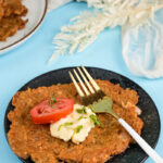 Plated German potato pancake with fresh herb garnish