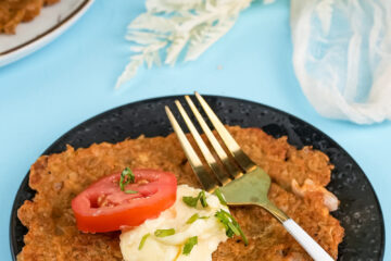 Plated German potato pancake with fresh herb garnish