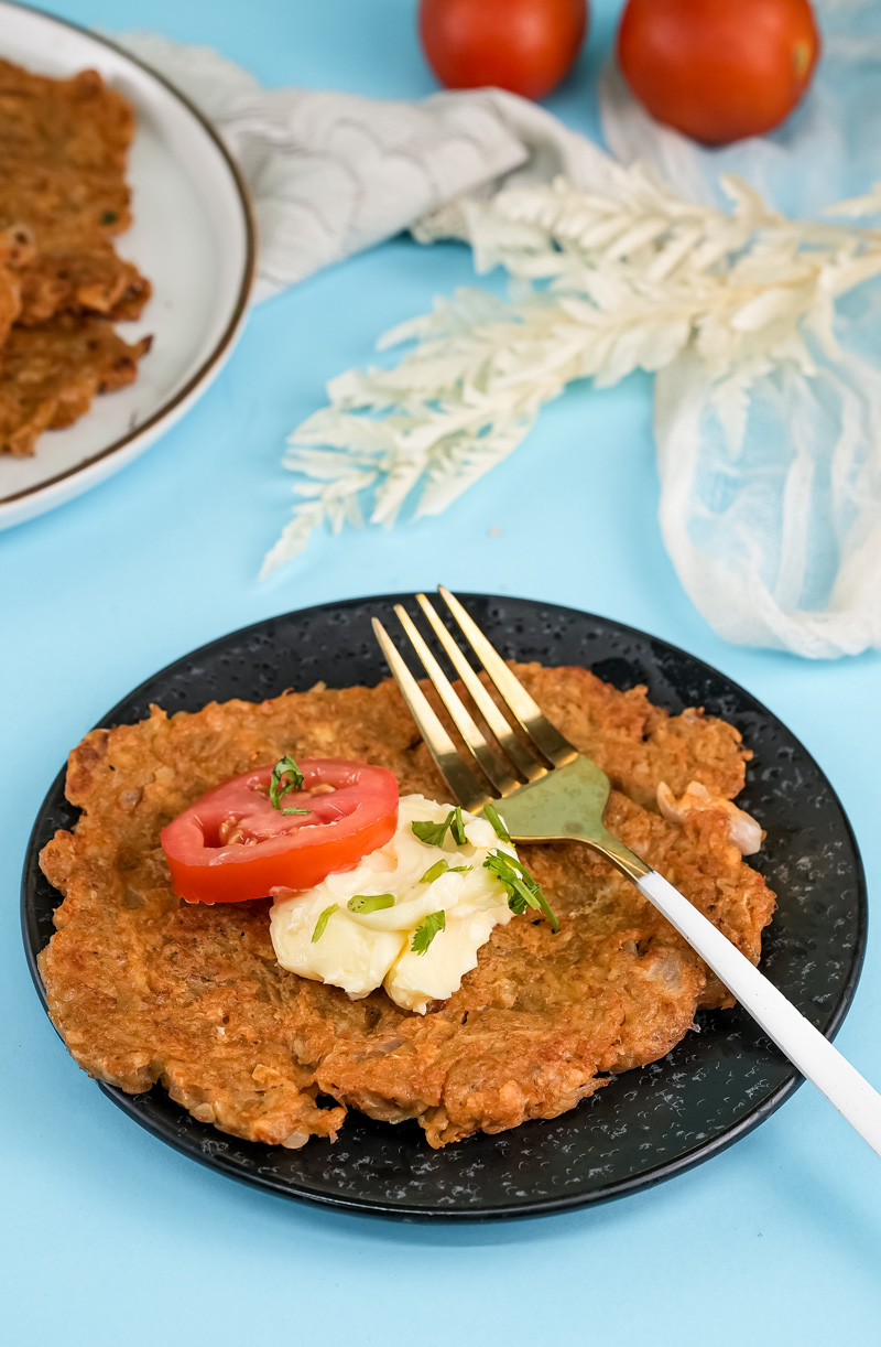 Plated German potato pancake with fresh herb garnish