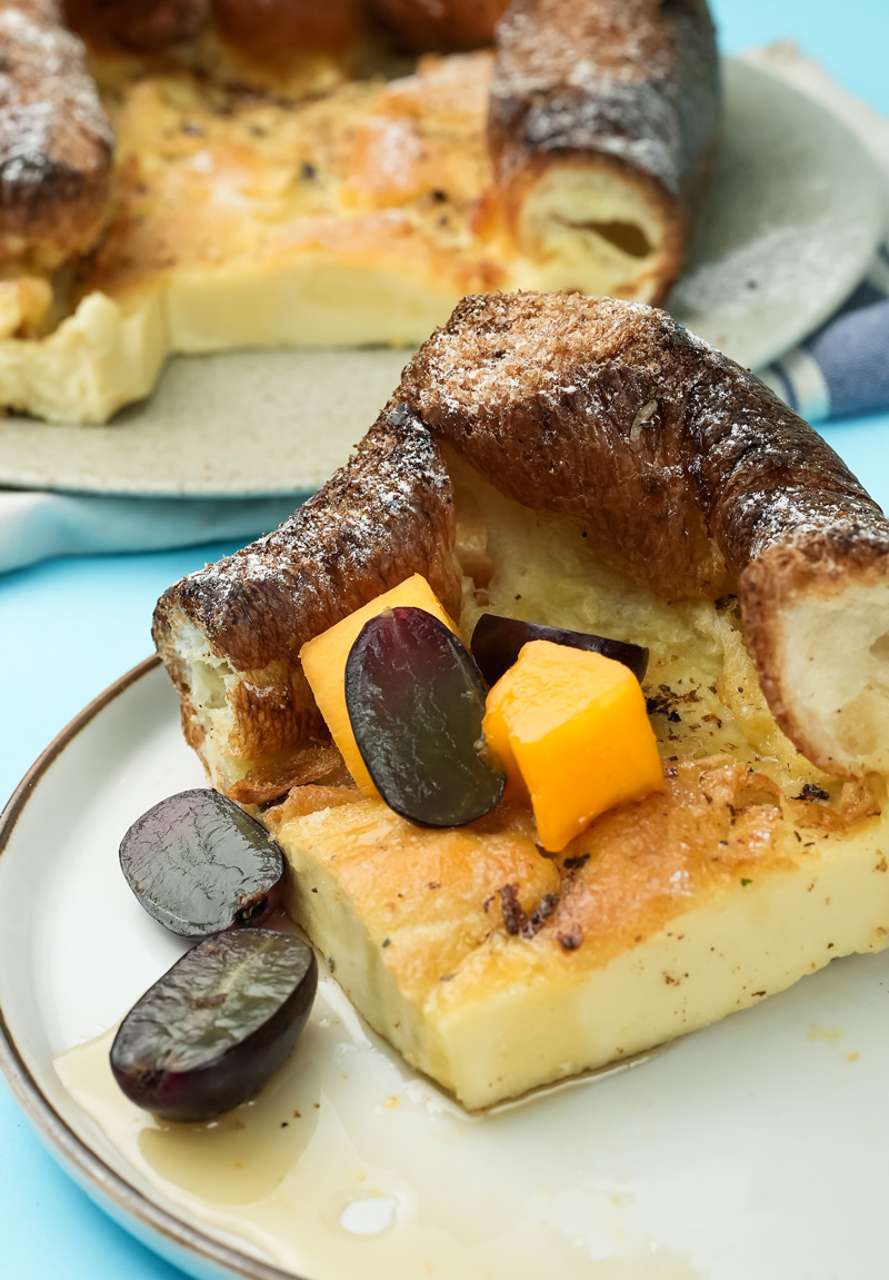 German pancake serving with orange cubes and grape garnish