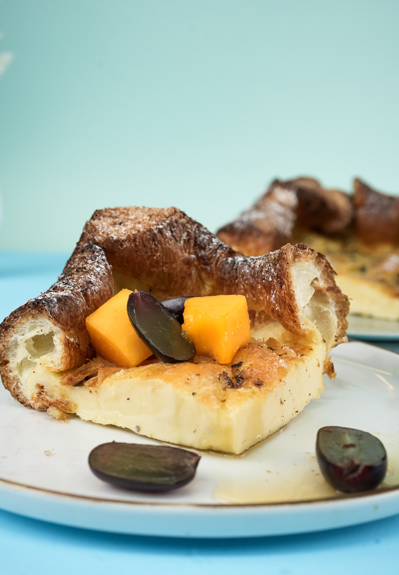 German pancake slice with fresh fruit garnish on white plate