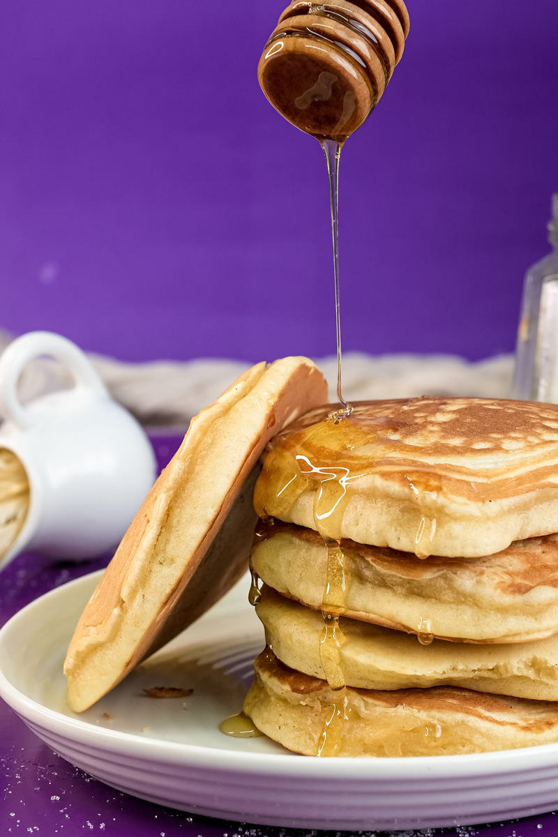 Gluten-free pancakes with honey drizzle and honey dipper