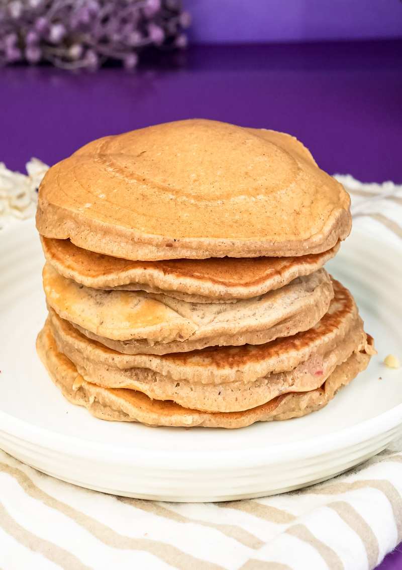 Golden brown peanut butter pancakes stacked on serving plate