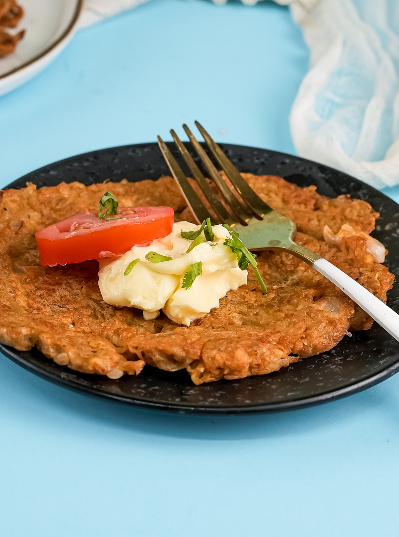Golden brown potato pancake with sour cream dollop