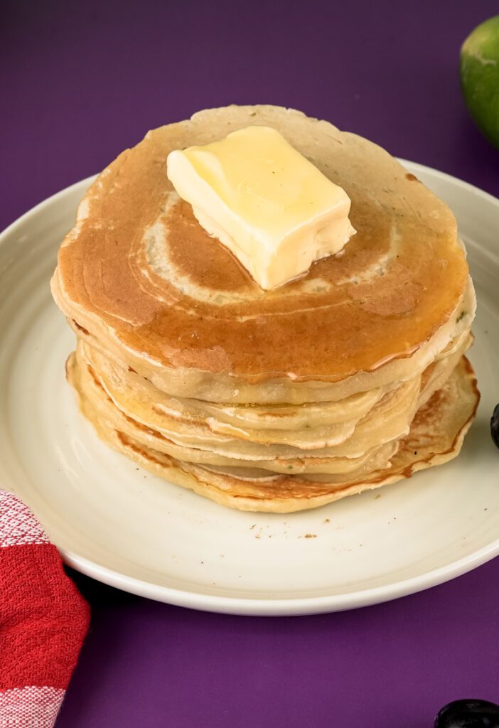 Golden lemon ricotta pancakes stacked high with melting butter