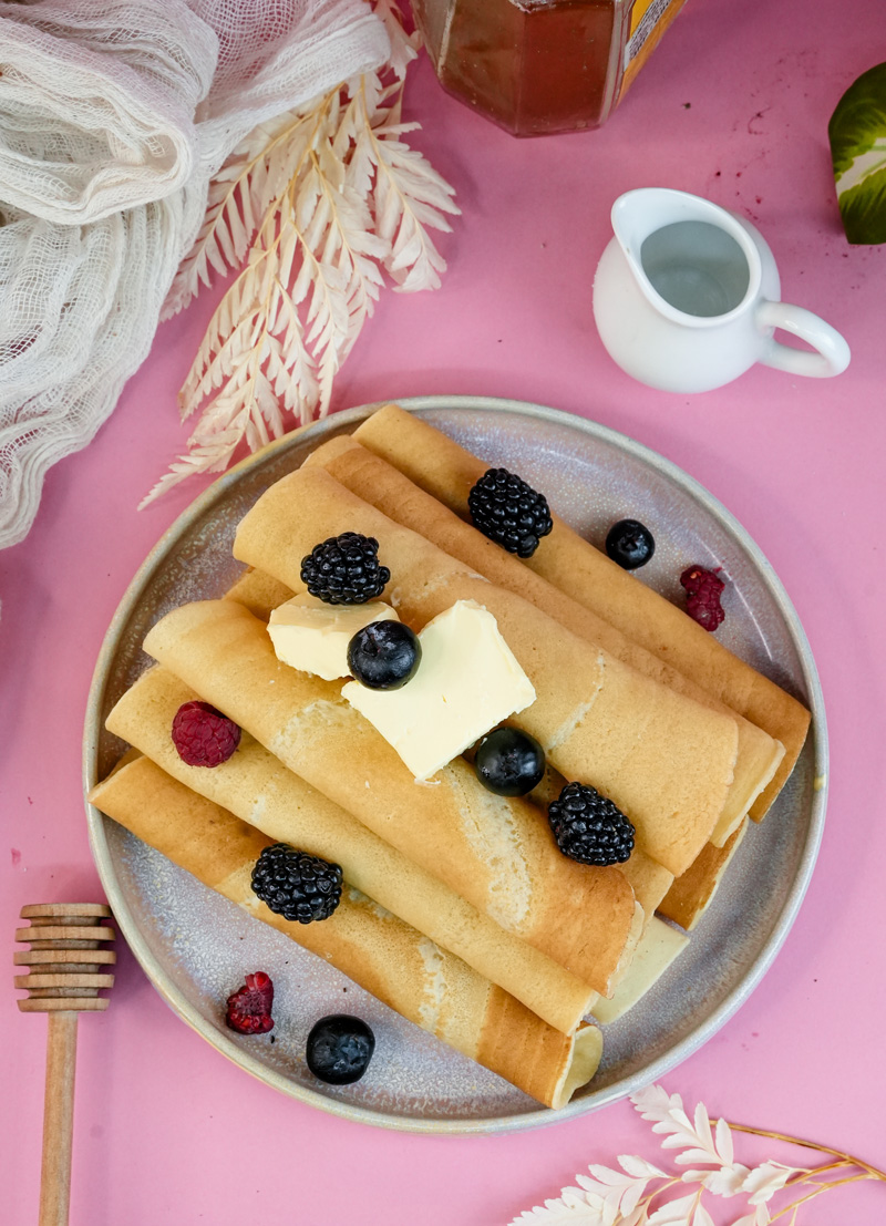 Golden pancake rolls topped with blackberries and blueberries