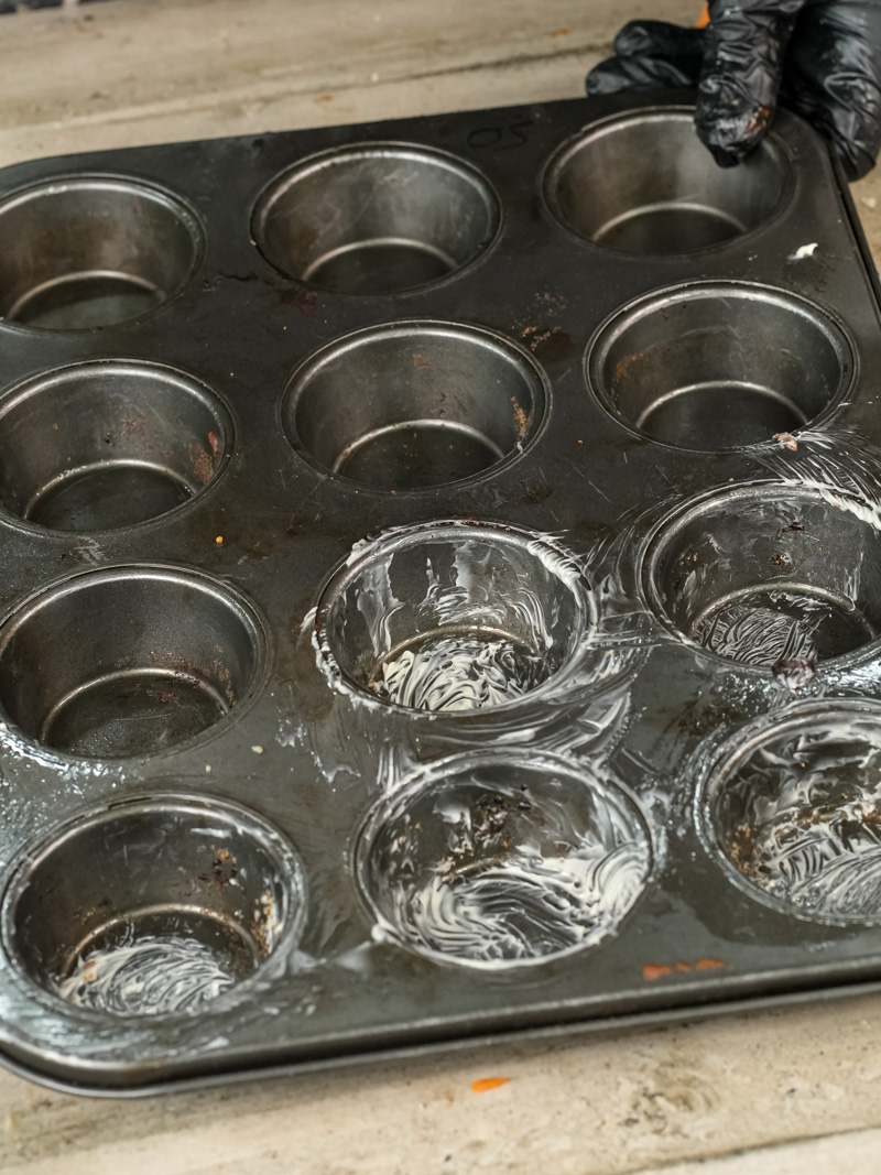 Greased muffin tin prepared for pizza muffin baking