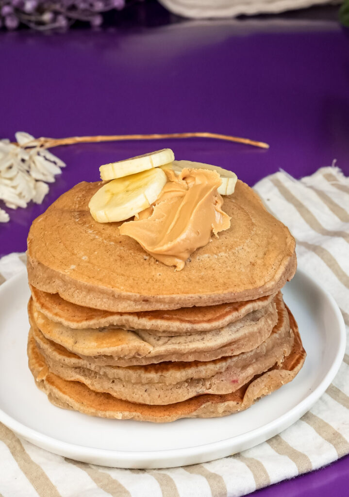 Homemade peanut butter pancakes with fresh banana and peanut butter topping