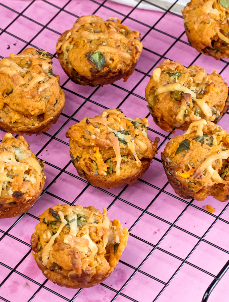 Homemade pizza muffins cooling on black wire rack