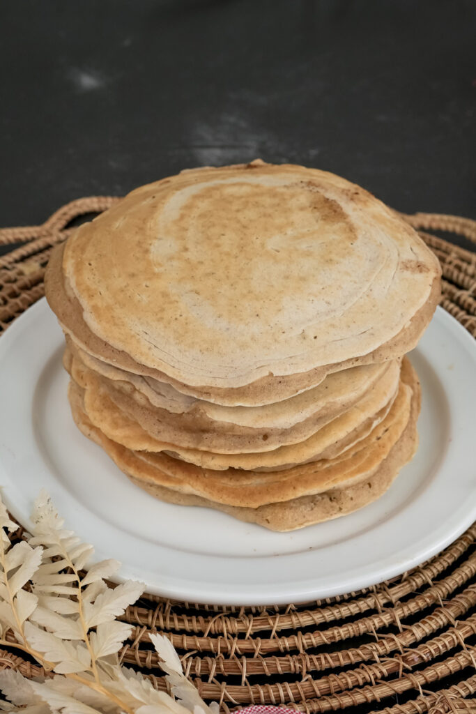 Homemade whole wheat pancakes ready to serve on woven placemat