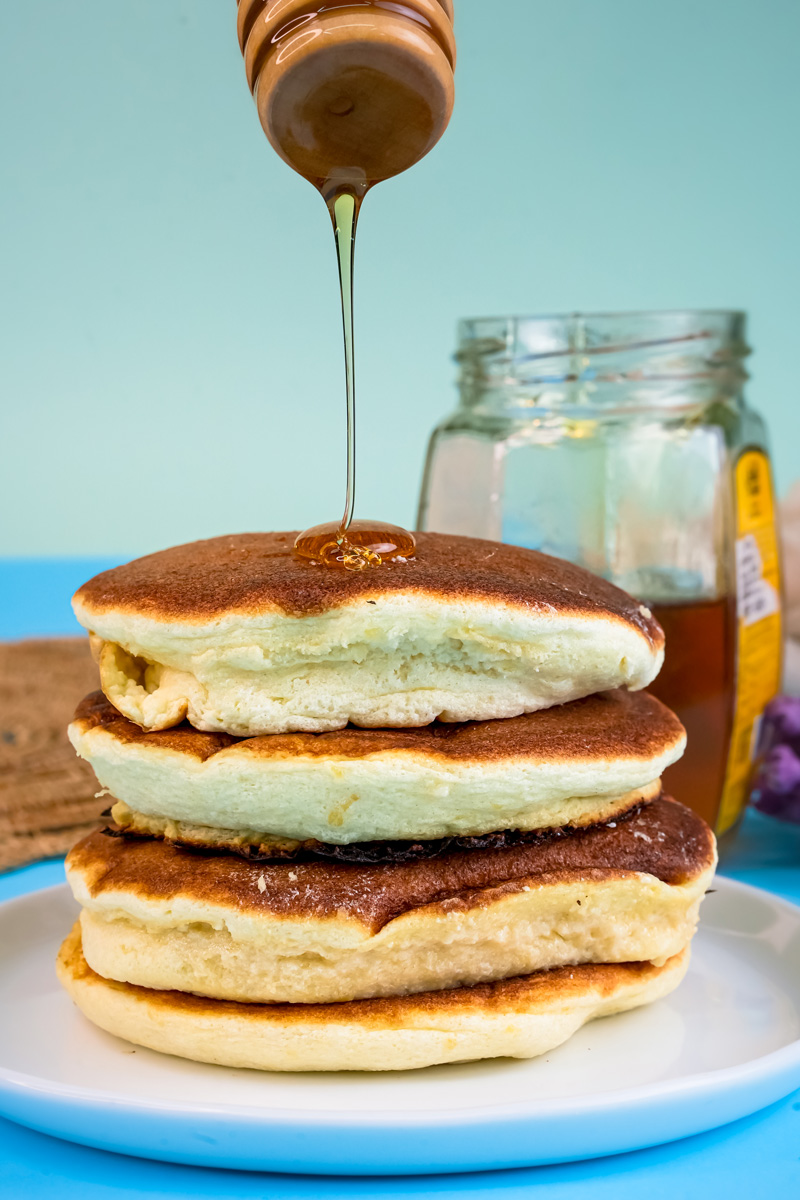 Honey drizzling on stack of Japanese pancakes