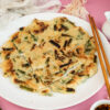 Final Korean scallion pancake presentation with chopsticks and sauce