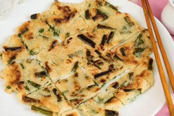 Final Korean scallion pancake presentation with chopsticks and sauce