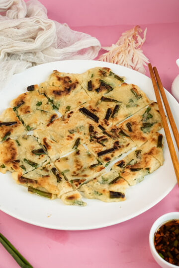 Final Korean scallion pancake presentation with chopsticks and sauce