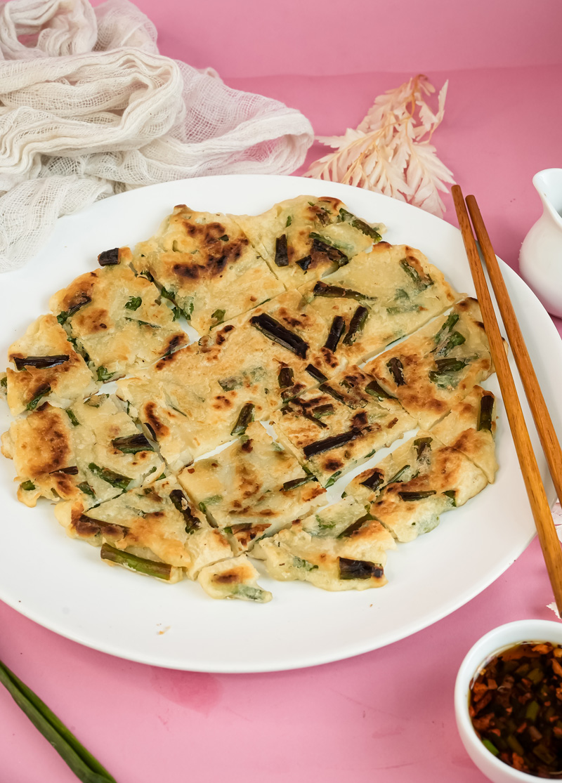 Final Korean scallion pancake presentation with chopsticks and sauce