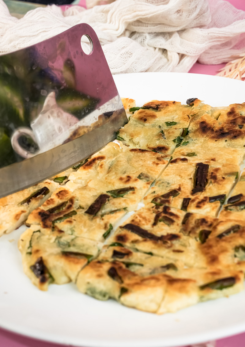 Korean scallion pancake cut into pieces with soy dipping sauce