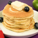Lemon ricotta pancake stack topped with butter and fresh blueberries