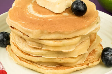 Lemon ricotta pancake stack topped with butter and fresh blueberries