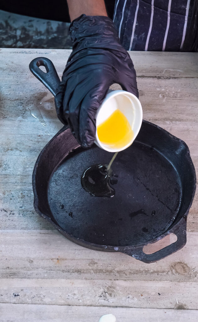 Melted butter being poured into cast iron pan for Dutch baby