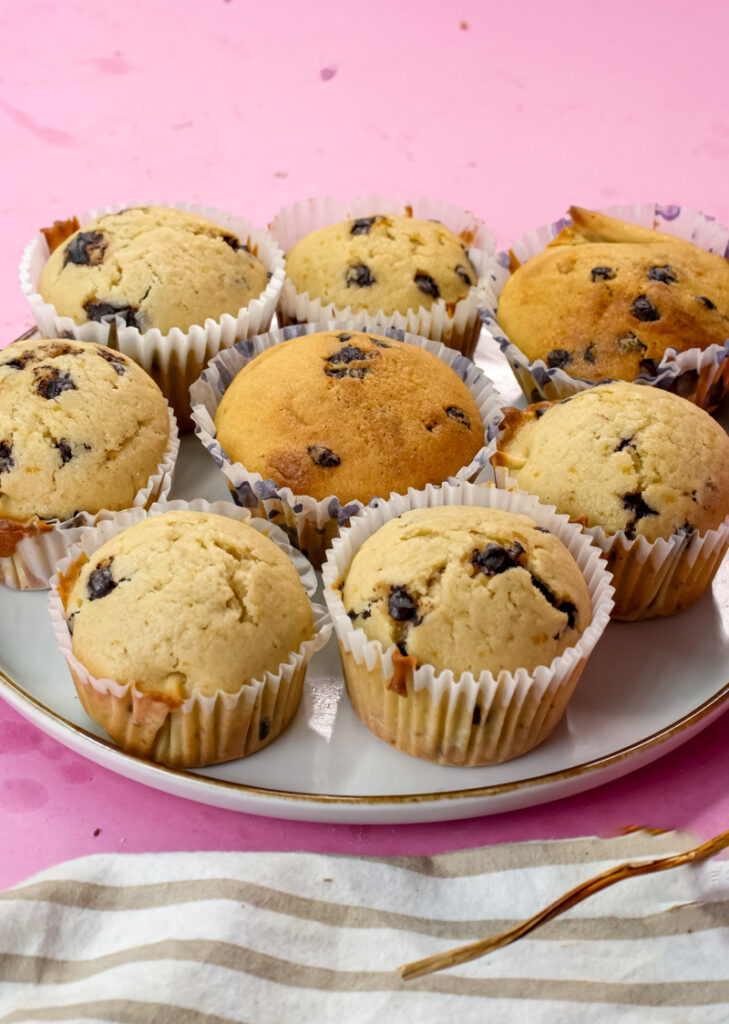 Mini chocolate chip muffins arranged on white plate with gold rim