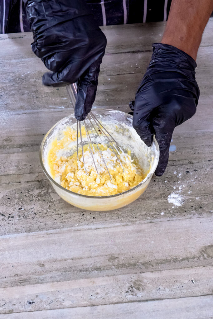 Mixing Japanese pancake batter with whisk in glass bowl