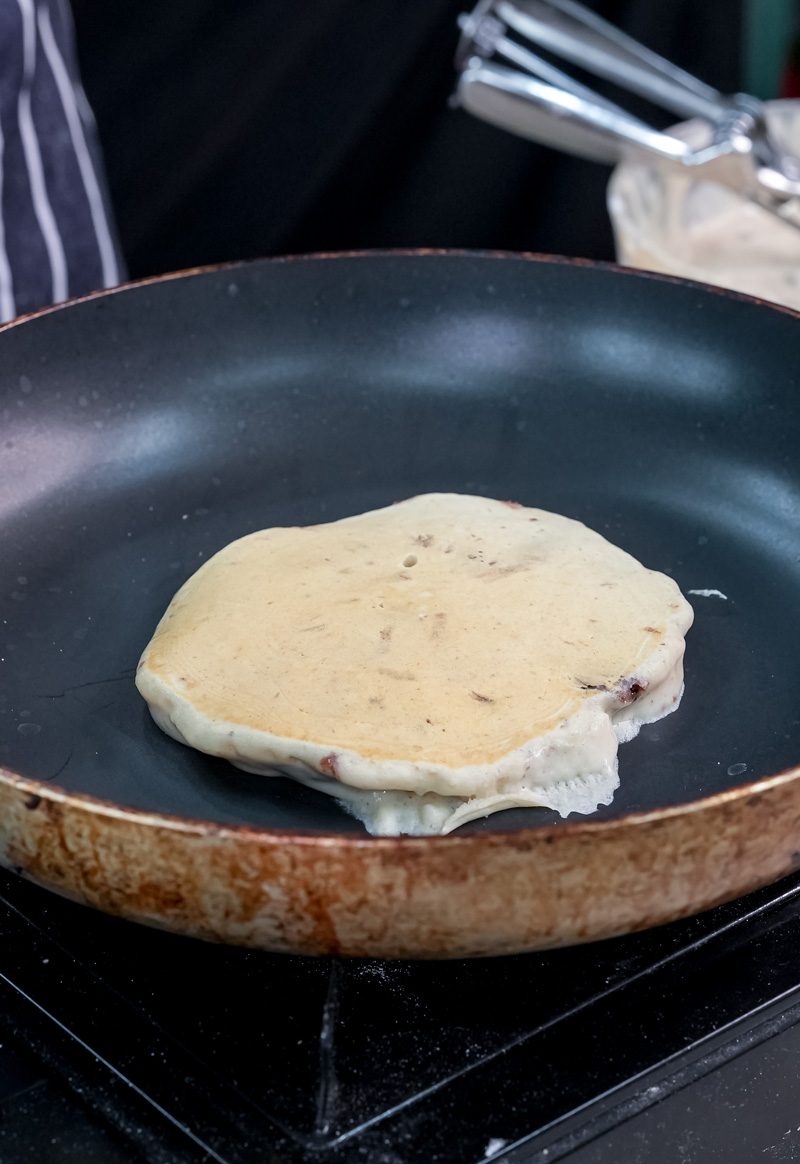 Oreo pancake cooking in non-stick pan on stovetop