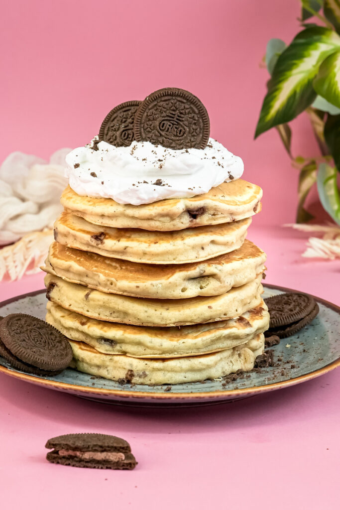 Oreo pancake stack topped with whipped cream and chocolate cookie halves