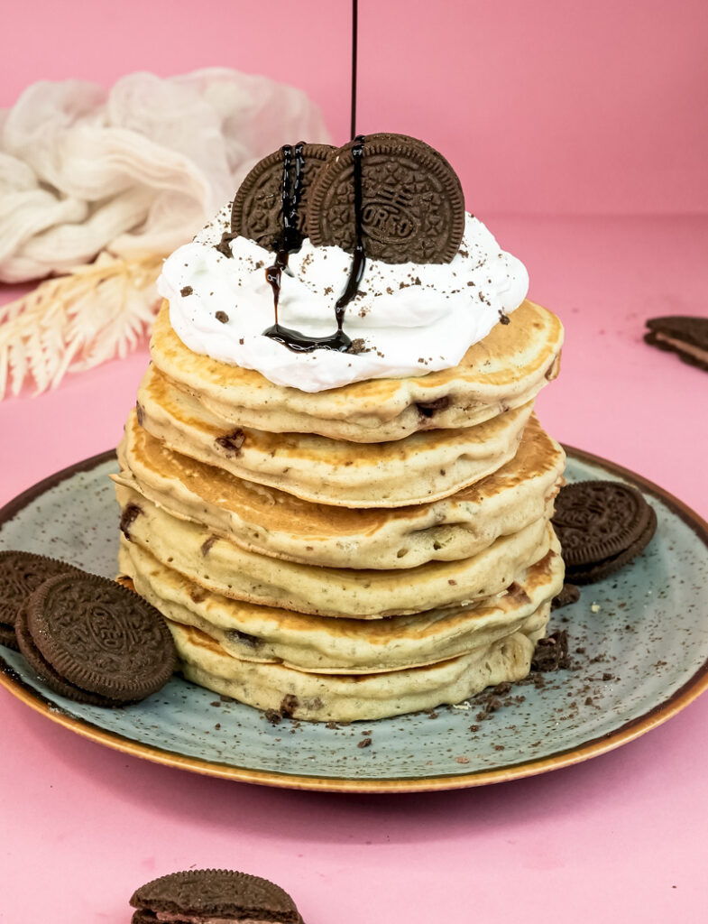 Oreo pancakes with chocolate syrup drizzle and Oreo cookie garnish
