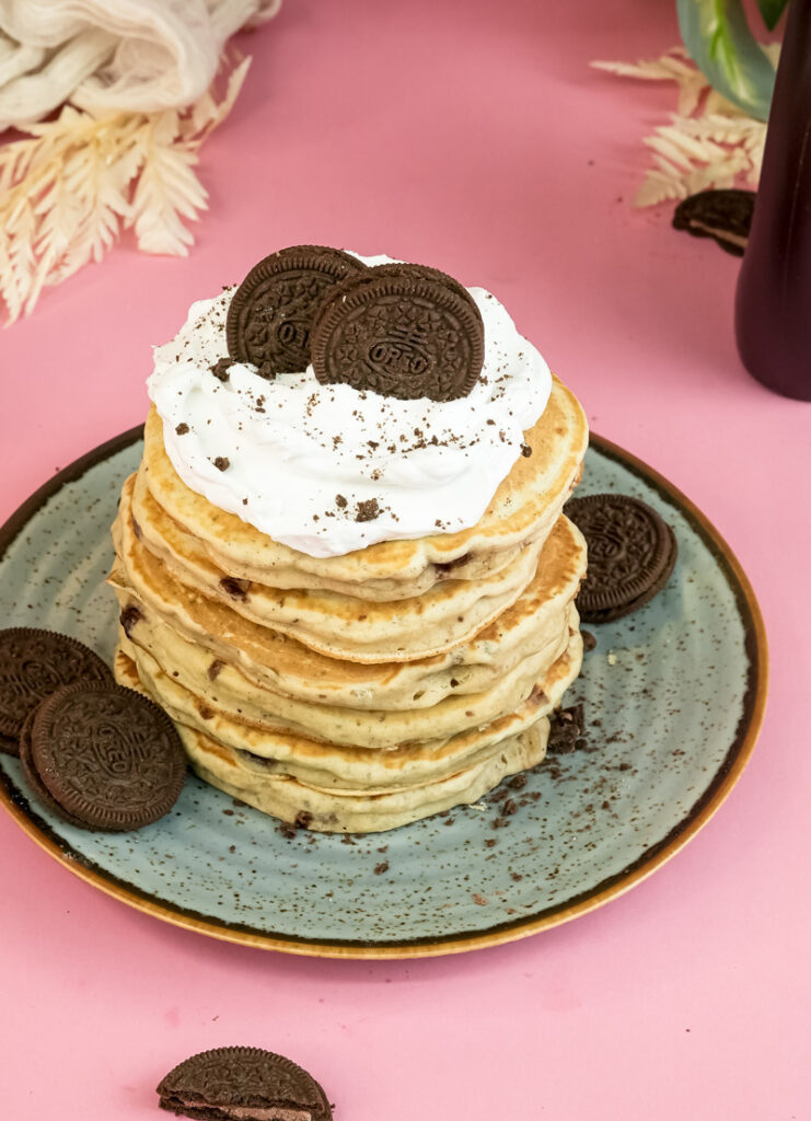 Oreo pancakes with whipped cream and two Oreo cookie halves on top