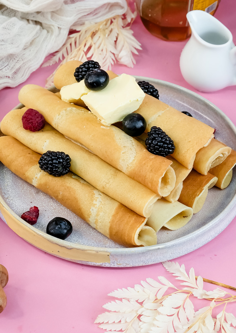 Plated pancake rolls with fresh berries breakfast presentation