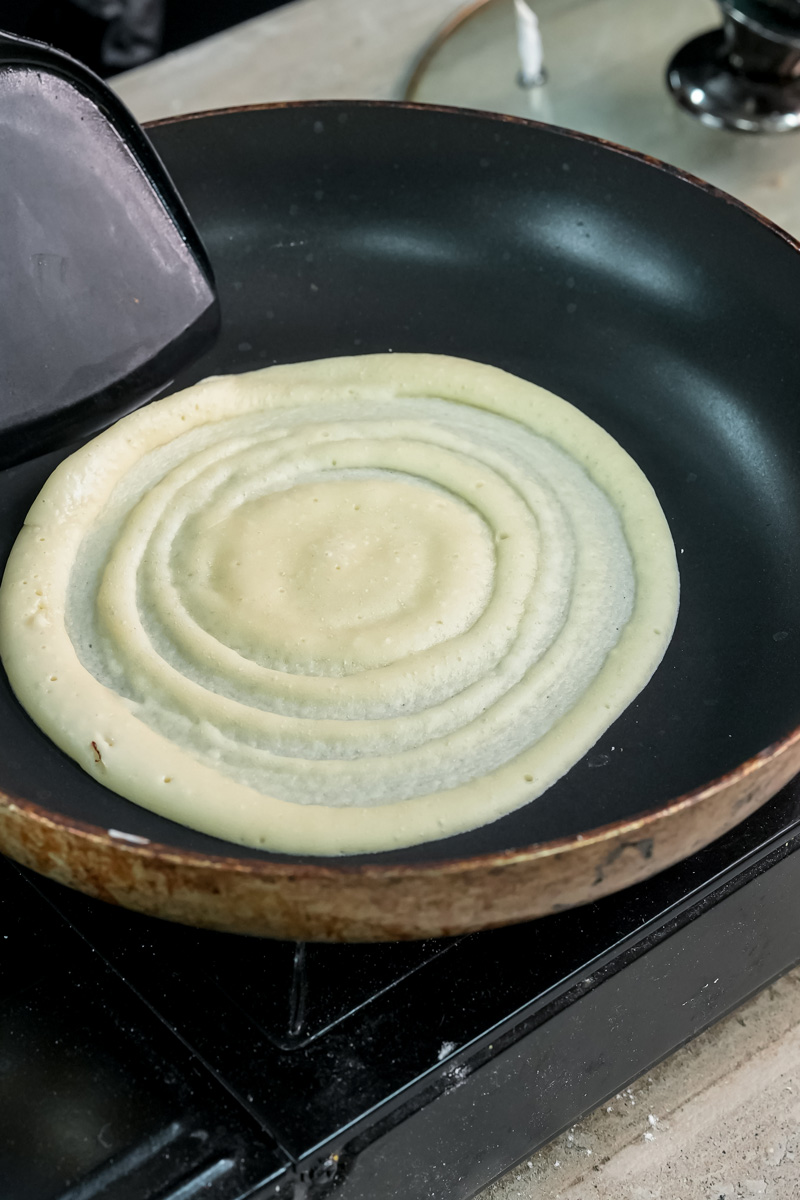 Pancake roll cooking in pan without lid