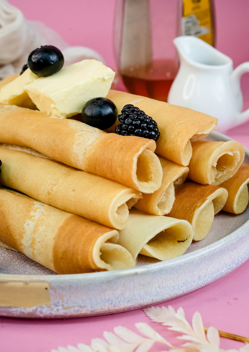 Pancake rolls garnished with mixed berries and cream cheese