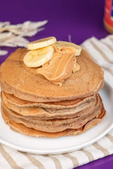 Breakfast stack of peanut butter pancakes with banana topping