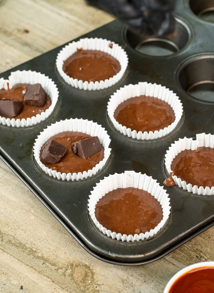Peanut butter banana muffin batter in muffin tin with chocolate chips