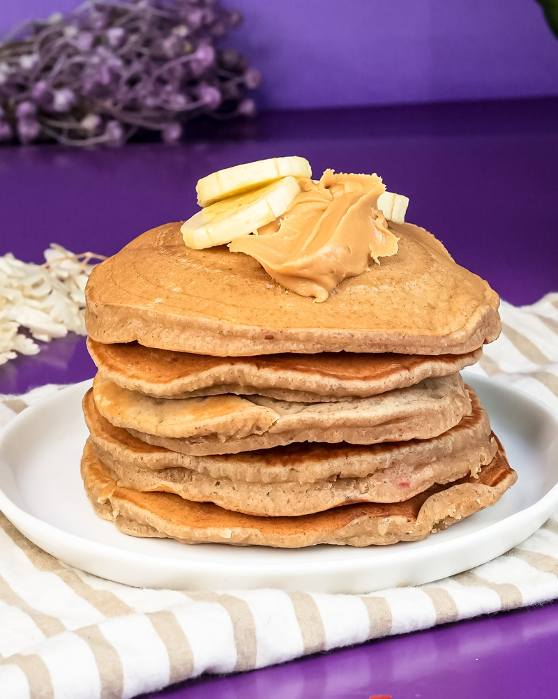 Peanut butter pancakes topped with banana slices and peanut butter