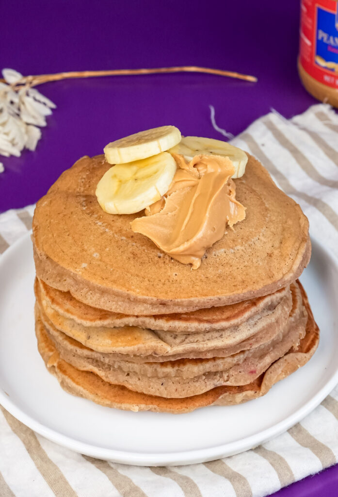 Close-up of peanut butter pancakes with banana and peanut butter garnish
