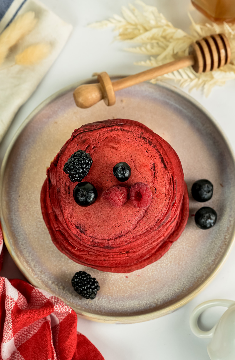 Plated red velvet pancakes with berry topping