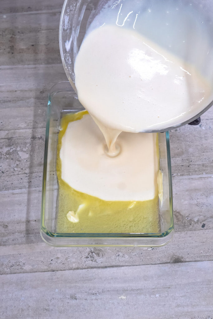 Pouring German pancake batter into greased baking dish
