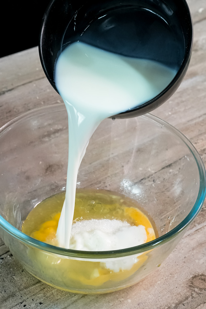 Pouring milk into bowl with egg for pancake roll batter