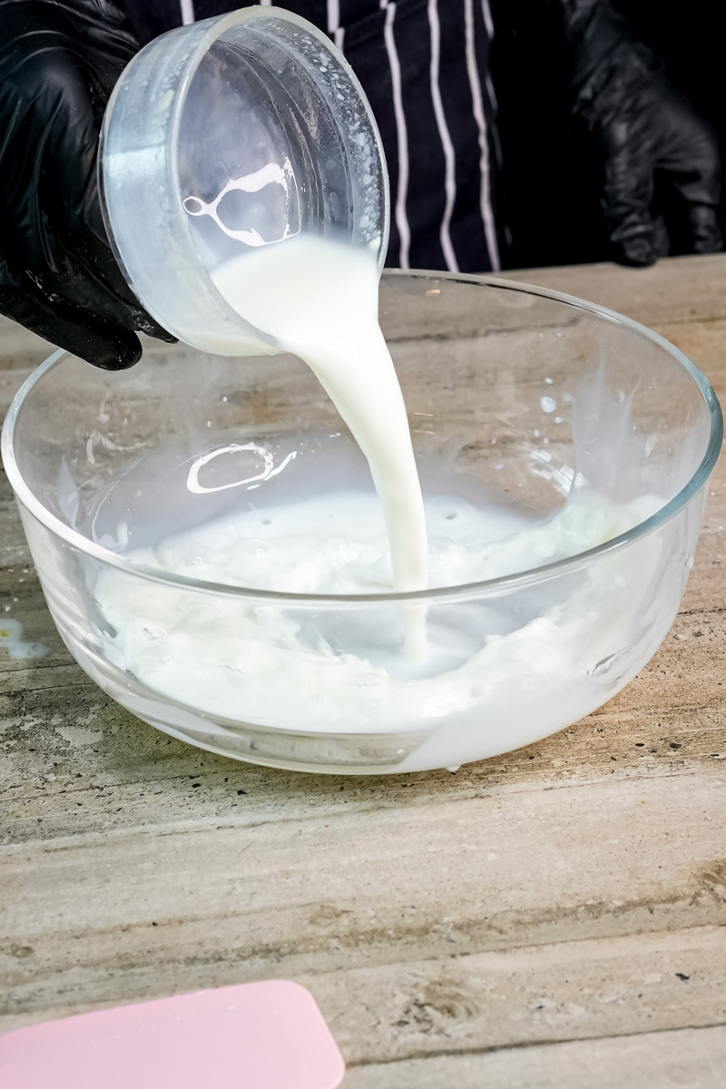 Pouring milk into glass mixing bowl for silver dollar pancake batter